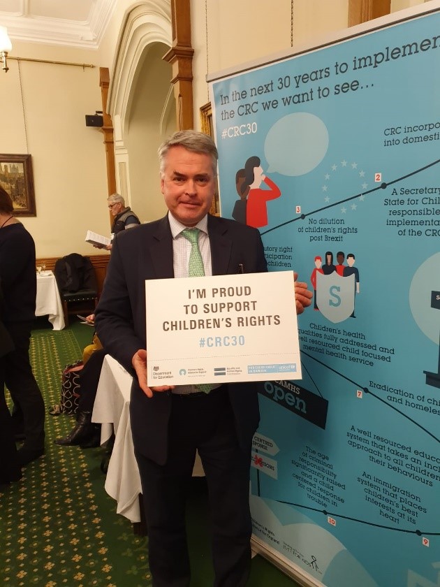 MP holding sign reading 'I'm proud to support children's rights'